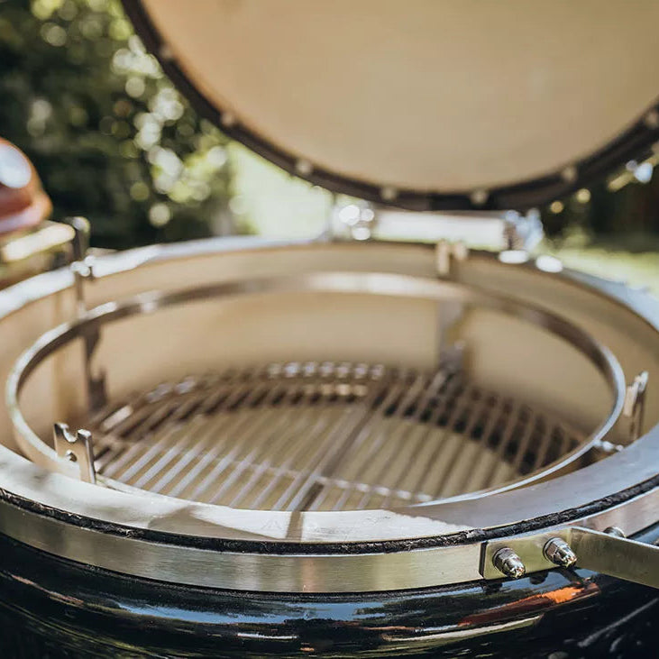
                  
                    Close-up of a ceramic kamado grill with a blurred outdoor background
                  
                